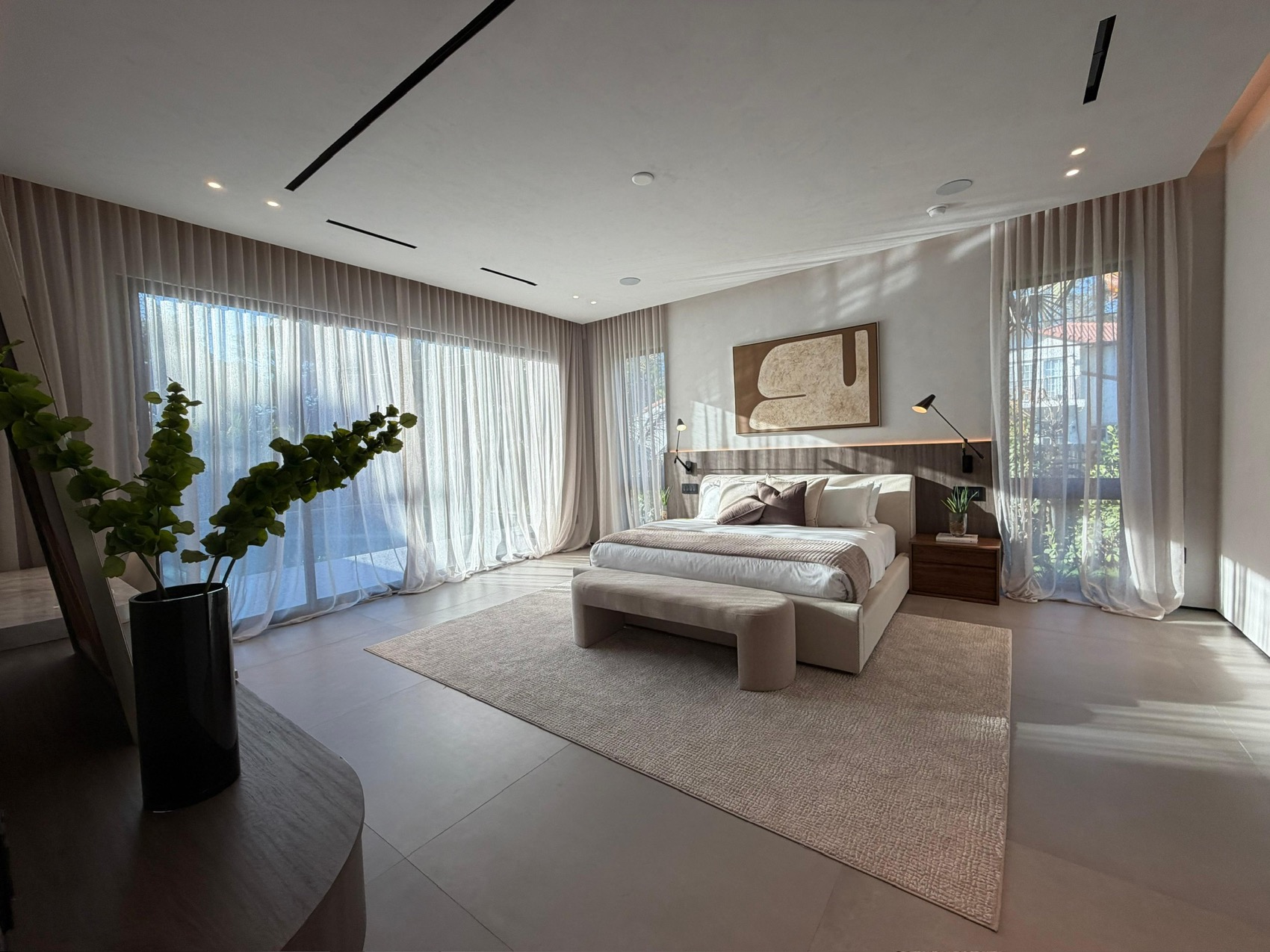 Custom sheer drapery on floor-to-ceiling corner windows in a Miami master bedroom