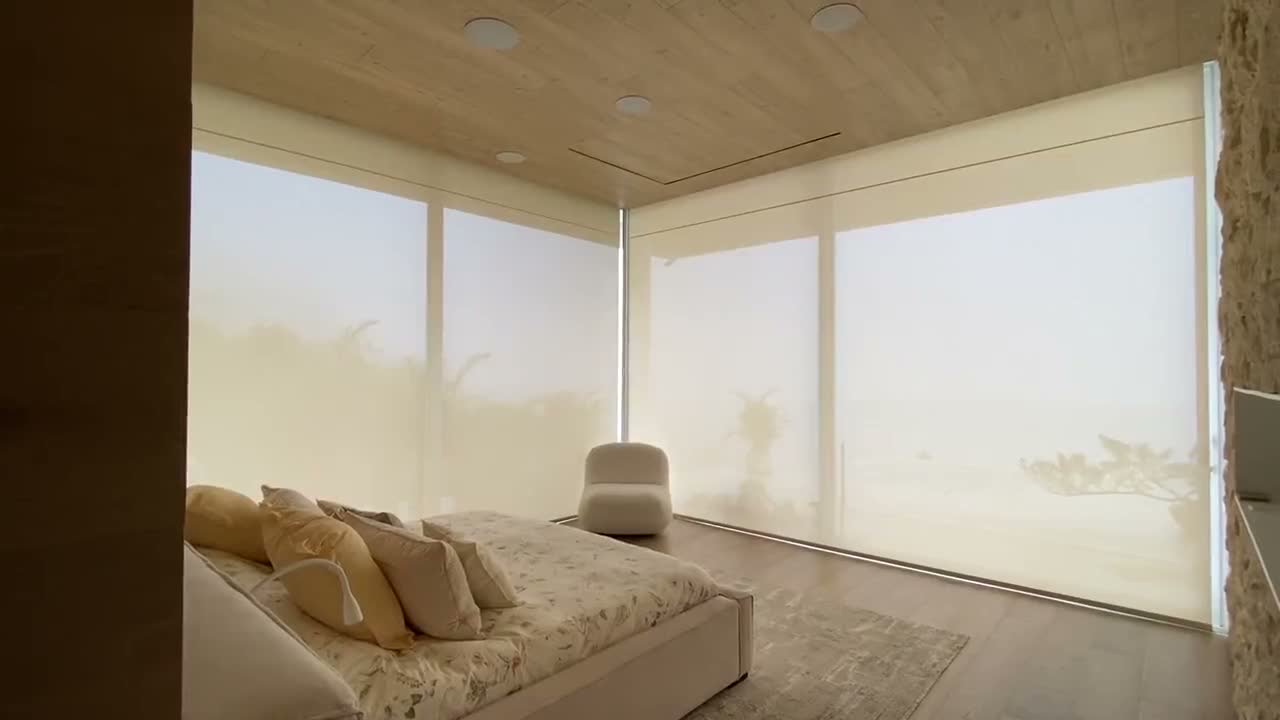Motorized solar shades in a Miami bedroom with ocean view