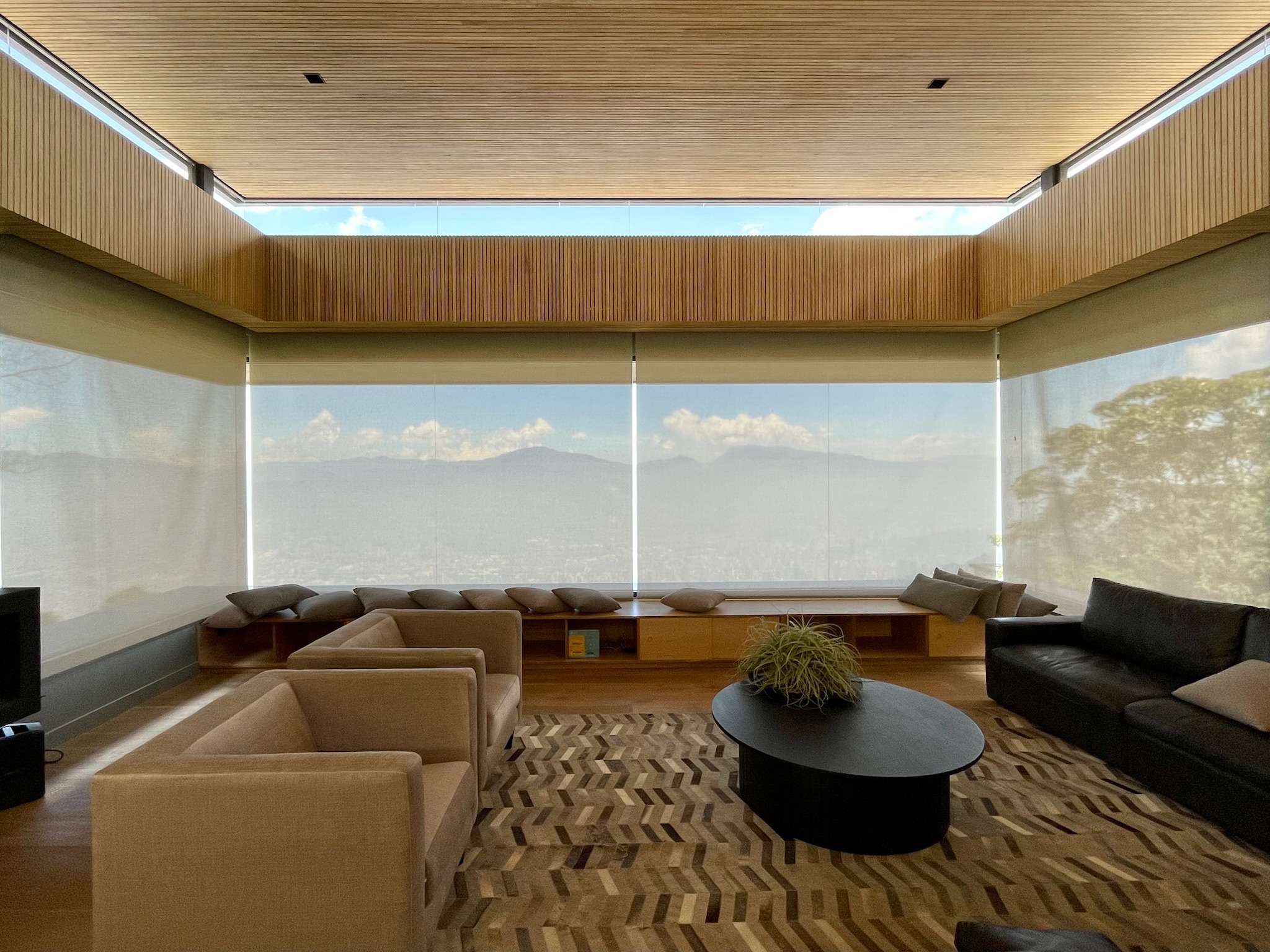 Panoramic motorized solar shades framing a mountain view